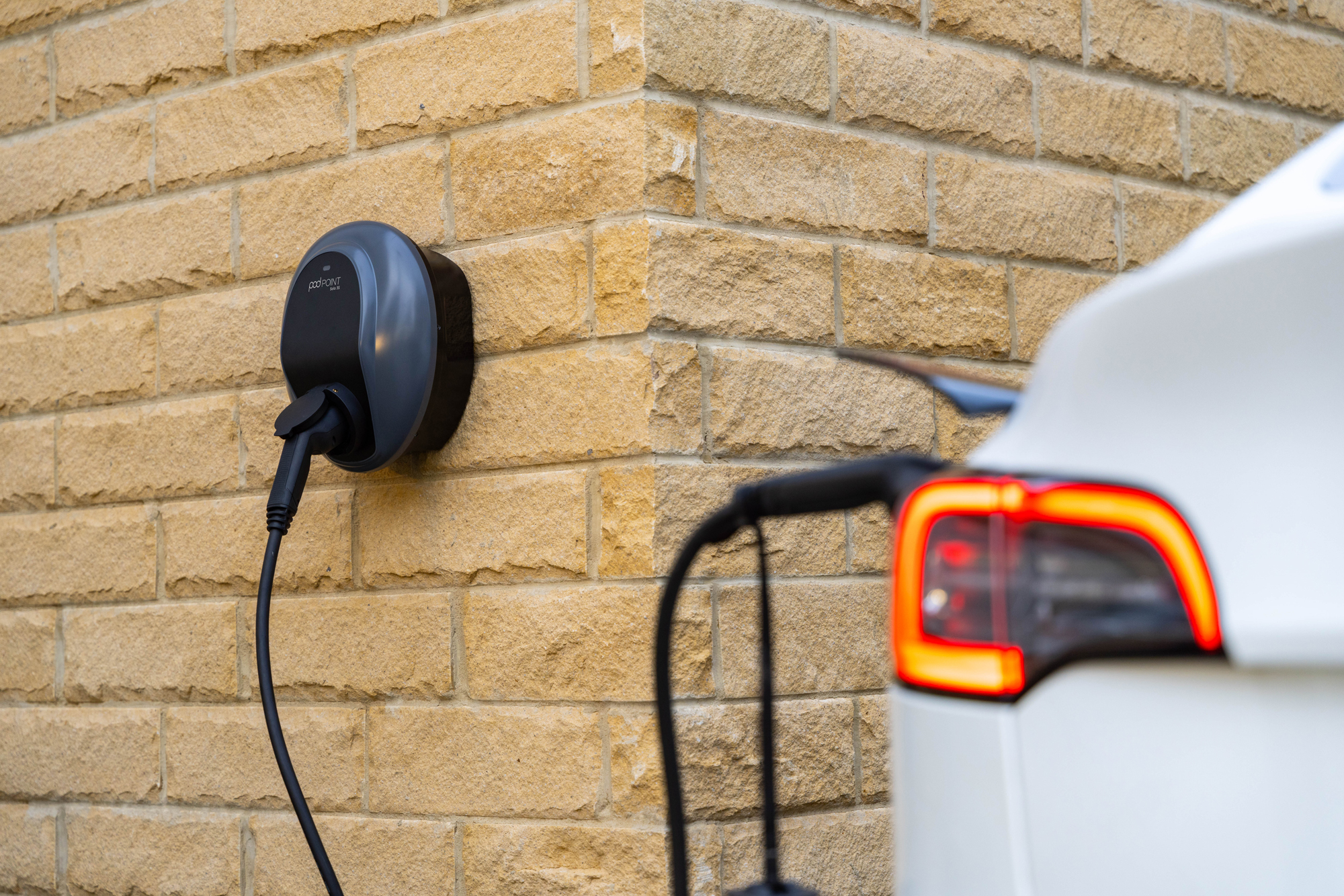 tesla next to a wall charger