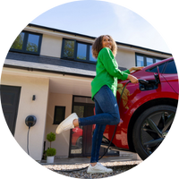 Pod Point domestic Solo 3 installed on a grey slate wall and plugged in to a grey car parked in front