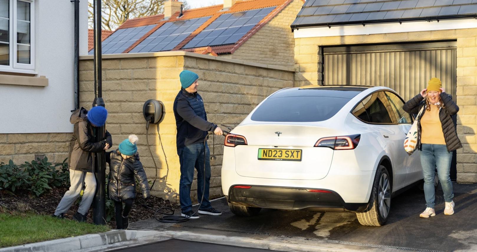 happy family charging a tesla model 3