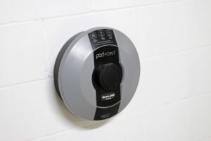 A close up of a Pod Point Solo installed on a white brick wall