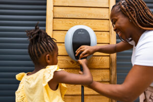 A close up of mother and daughter both plugging the socket into a Pod Point Solo 3