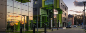 3 Pod Point twin chargers in front of modern workplace building