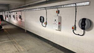 A line of Pod Point Solo 3's installed on a white wall in an indoor car park