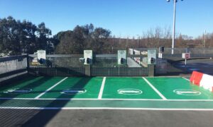 A wide shot of 4 green EV parking bays with 4 Pod Point Solo 3's at Southampton airport car park