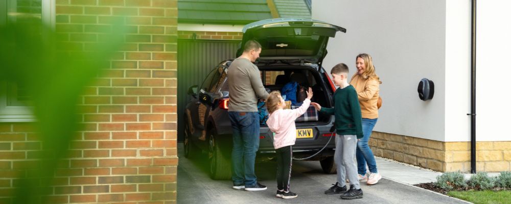 Family with their EV plugged into a Solo 3S home charger
