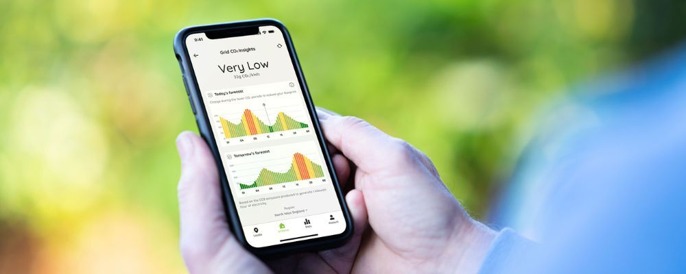 A person looking at the Grid CO<sub>2</sub> Insights feature on their phone