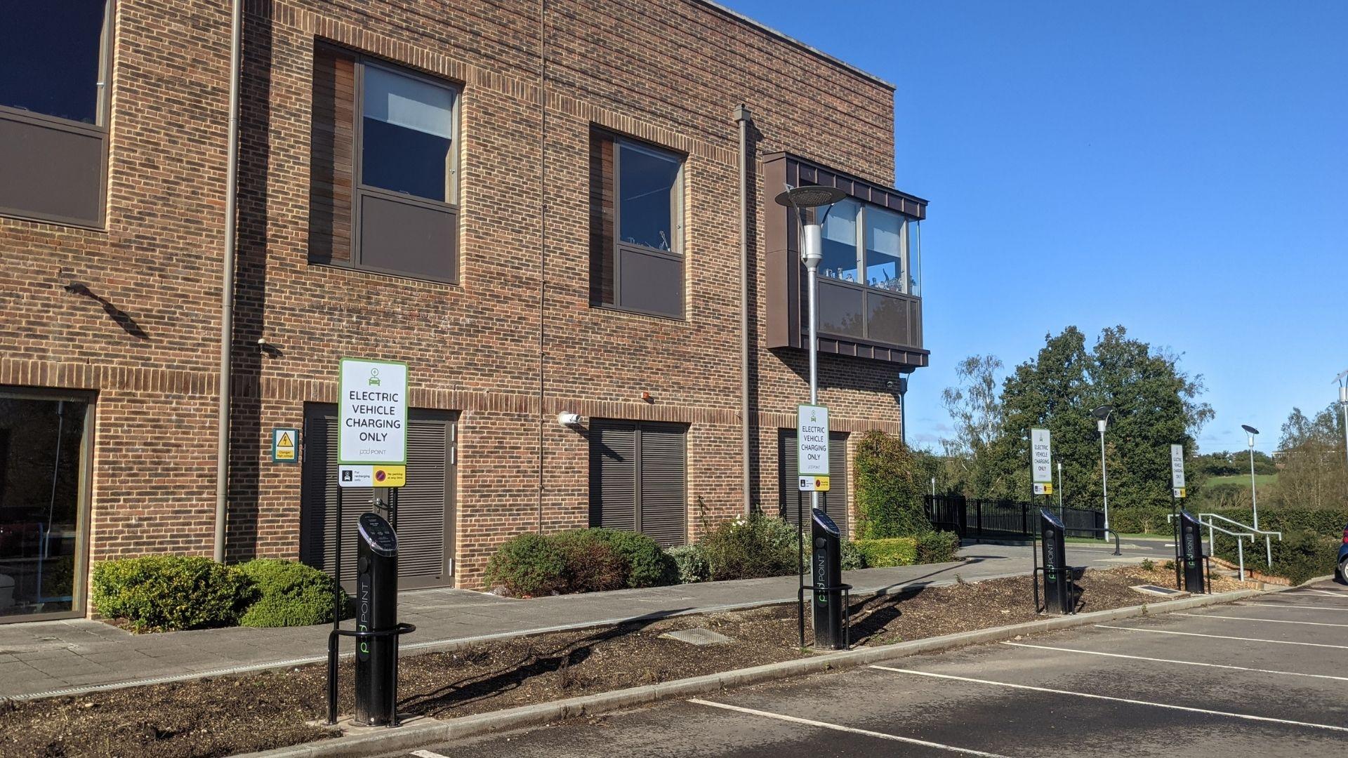 A line of Pod Point twin chargers installed with signage above each charger in Merchant Taylor's car park