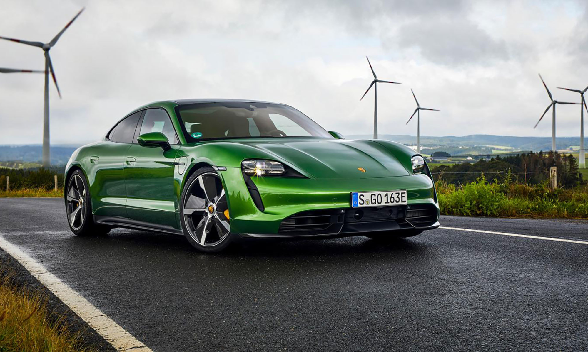 porsche taycan with wind turbines in the background